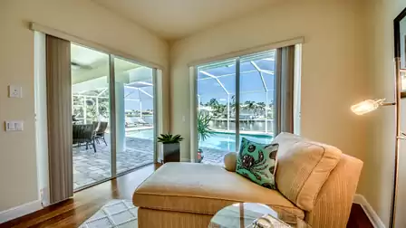 Cozy reading corner in the master bedroom with a panoramic view of the pool area and canal.