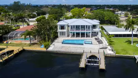 Aerial view of Villa River King directly on the riverfront with a private boat dock and upscale architecture.