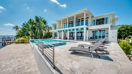 Elegant entrance with tropical landscaping and stylish green accents.