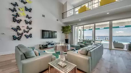 Modern living room with high ceilings, leather sofas, and butterfly wall art