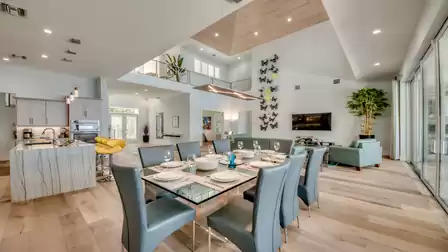 Elegant dining area with glass table and stylish chairs, adjacent to the kitchen