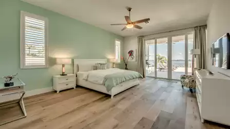 Bright bedroom with large windows, direct terrace access, and ocean view.