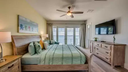Spacious bedroom with wooden interior, direct balcony access, and river view.