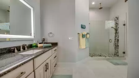 Modern bathroom with double sinks, large shower, and stylish decor.