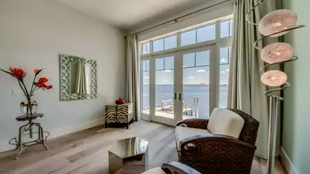 Cozy seating area with large windows, elegant decor, and a stunning river view.