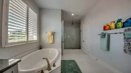 Bathroom with bathtub, towels, and large walk-in shower.