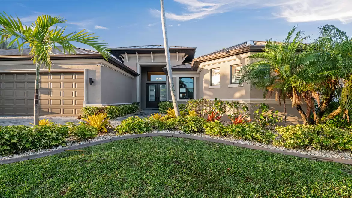 Entrance area of Villa Elvenar, surrounded by tropical landscaping and stylish design.
