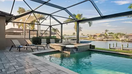 Pool with waterfall spa and stunning sunset view in Cape Coral.
