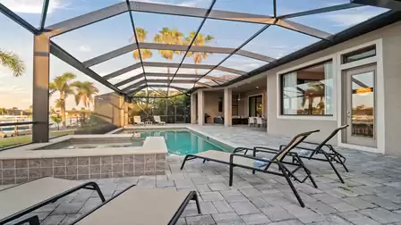 Spacious pool area of Villa Elvenar with covered patio and outdoor dining area.