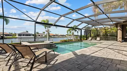 Expansive terrace with pool and canal view – perfect for relaxing vacation days.