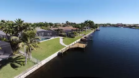 Panoramic view of the wide canal with tropical surroundings and well-maintained properties.
