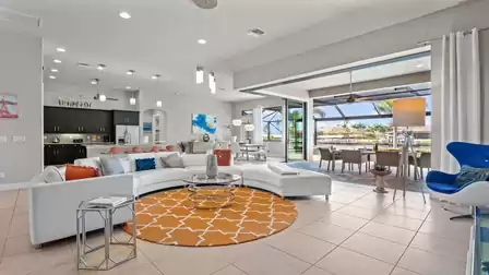 Open living area with modern furnishings, spacious seating, and a view of the pool and canal.
