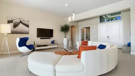 Stylishly furnished living room with a bright sofa set, blue accents, and wall art.