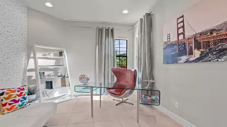 Modern office with a glass desk, comfortable chair, and a view outside.
