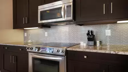 Modern kitchen with stainless steel appliances, dark wood cabinets