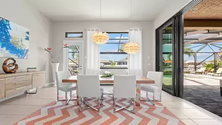 Dining area with designer pendant lights, open to the terrace with a stunning view of the waterway.