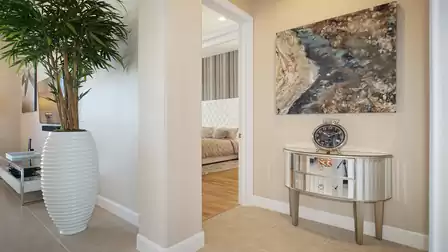 Elegant hallway with a large vase, wall art, and a view into the luxurious bedroom.