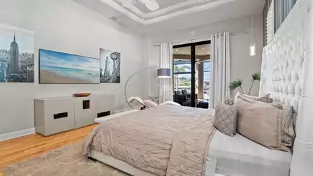 Master bedroom with high-quality furnishings, modern artwork, and access to the pool terrace.