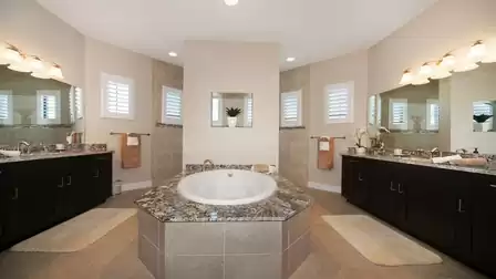 Luxurious bathroom with a large whirlpool bathtub, double sinks, and elegant mirrors.
