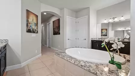 Modern bathroom with a spacious bathtub, granite vanity, and stylish accents.