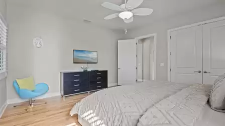 Bedroom with stylish decor, ceiling fan, and modern furnishings.
