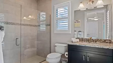 Modern bathroom with a spacious walk-in shower and elegant vanity area.