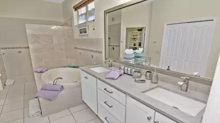 Bathroom with double sink, bathtub and walk-in shower