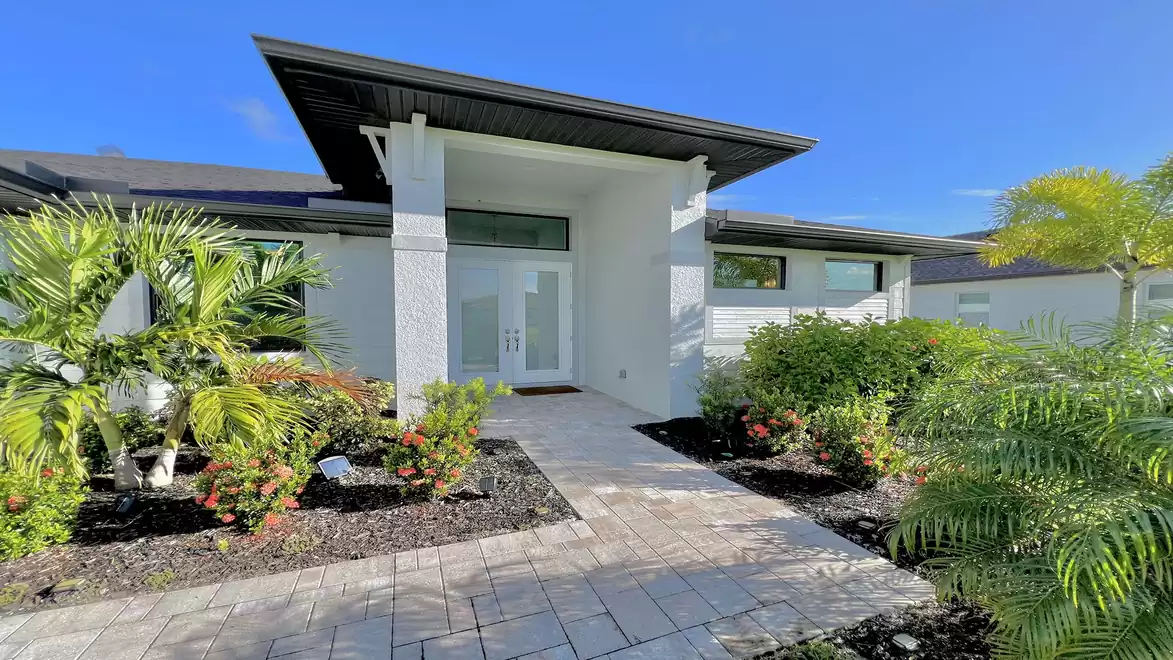 Entrance area with lush greenery and stylish architecture.