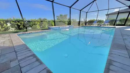 Spacious pool area with crystal-clear water and screen.