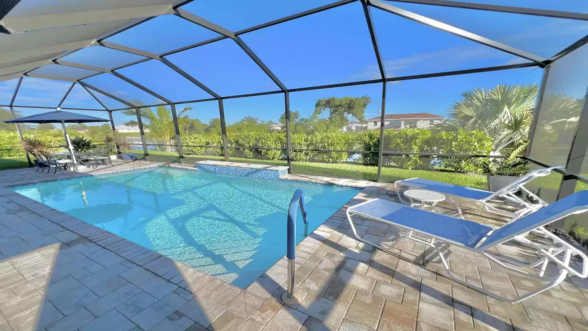 Pool with screened patio and cozy seating area.