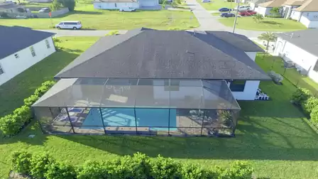 Backside of the house with screened pool area and green space.