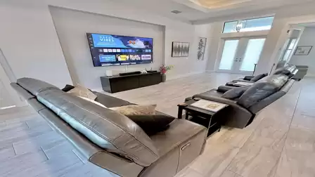 Living room with comfortable leather recliners and large TV.