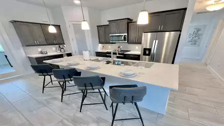 Modern kitchen with large island and bar stools.