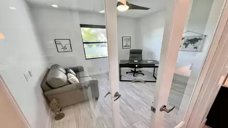 Bright office with glass double doors and modern furniture.