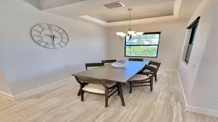 Dining room with large wooden table and elegant decor.