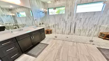 Large bathroom with walk-in shower and double sinks.