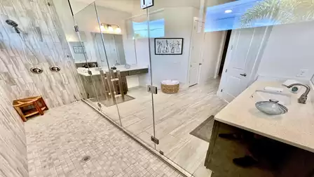 View through the shower into the modern bathroom area.