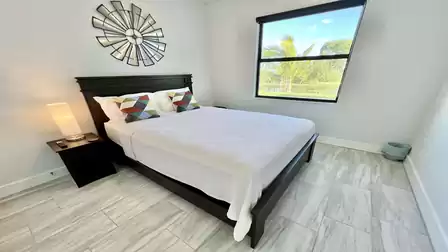 Modern guest room with dark bed and wall decor