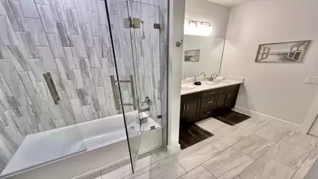 Modern bathroom with double vanity and glass shower