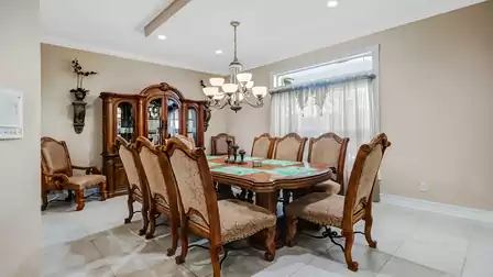 Elegant dining room with a large wooden table and sophisticated lighting.