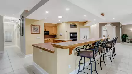 Stylish kitchen counter with bar stools and high-quality appliances.