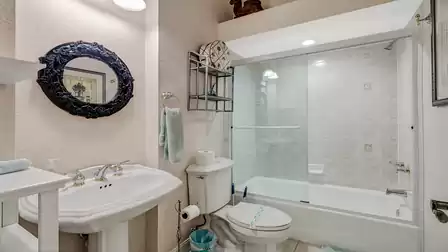 The stylish bathroom features a shower-bathtub combination and elegant accents.
