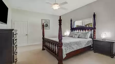 The master bedroom impresses with an intricately carved four-poster bed and a harmonious color scheme.