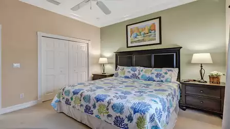 Elegant bedroom with a large king-size bed, stylish dark headboard, and soothing green tones.