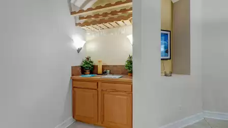 Small, cozy home bar with wine glass holder and warm lighting