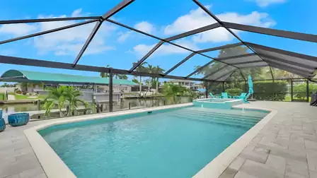 Pool and spa at Villa Kamala in Cape Coral with a screened patio and canal view.