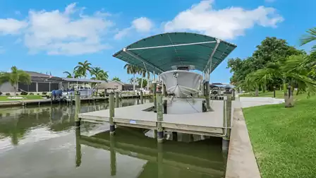 Private dock at Villa Kamala in Cape Coral with a boat lift and covered boat slip.
