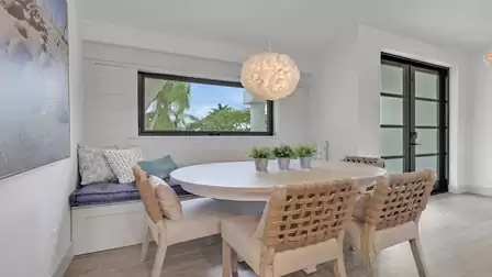 Bright dining area with a round dining table, built-in bench seating, and a modern window nook.