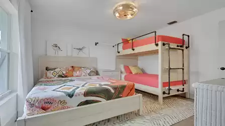 Bedroom with a queen-size bed, bunk bed, and bright interior, ideal for families and groups.