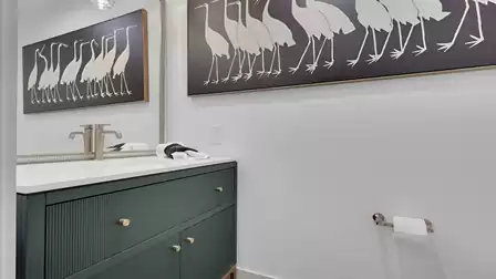 Modern half bathroom with a stylish vanity, large mirror, and decorative wall art.